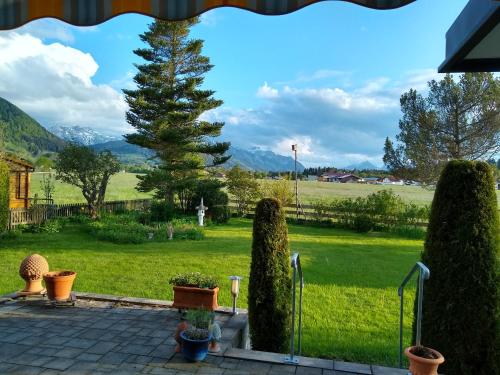 a view of a yard with trees and a field at Haus Christine in Halblech