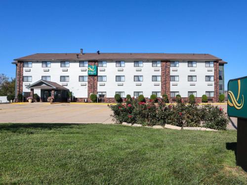a large white building with a large parking lot at Quality Inn & Suites Bloomington I-55 and I-74 in Bloomington