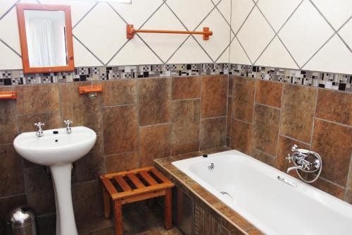 a bathroom with a bath tub and a sink at Ngwenya Boutique Hotel in Lephalale
