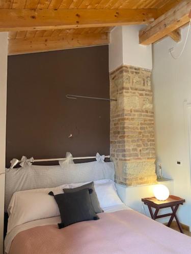 um quarto com uma cama e uma parede de tijolos em Locanda Il Cortile em Vignale