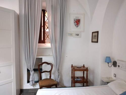 1 dormitorio con cama, ventana y silla en Sogno Romano, en Roma