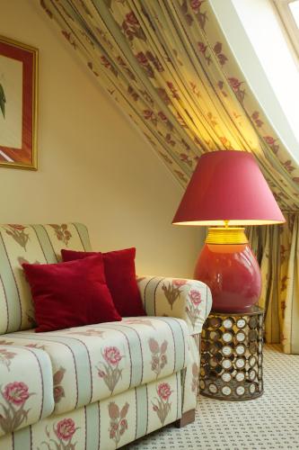 a living room with a couch and a red lamp at NARUTIS Hotel - Small Luxury Hotels of The World in Vilnius