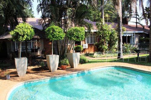 a swimming pool in front of a house at Ngwenya Boutique Hotel in Lephalale
