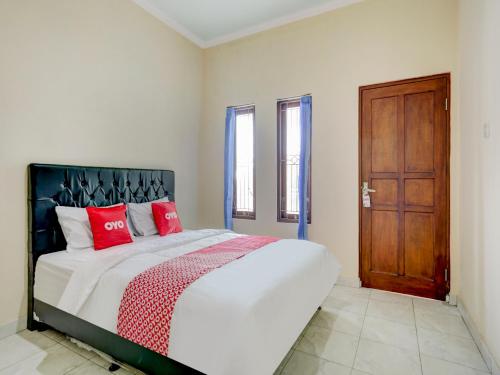 a bedroom with a large bed with red pillows at OYO 90690 Pondok Dukuh in Ungasan
