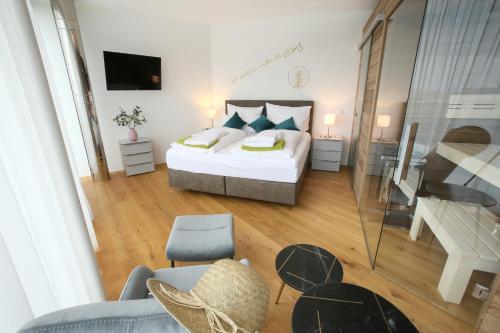 a bedroom with a bed and a living room at Seehaus LakeSide - Am Hafen in Neusiedl am See
