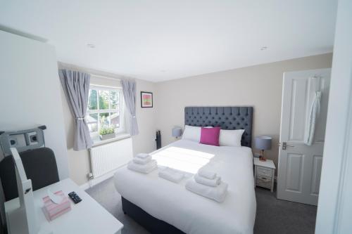 Un dormitorio con una gran cama blanca y una ventana en Peartree Serviced Apartments en Salisbury