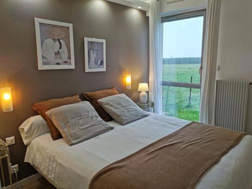 um quarto com uma cama grande e uma janela em Front de mer- Appartement standing 1 chambre em Calais