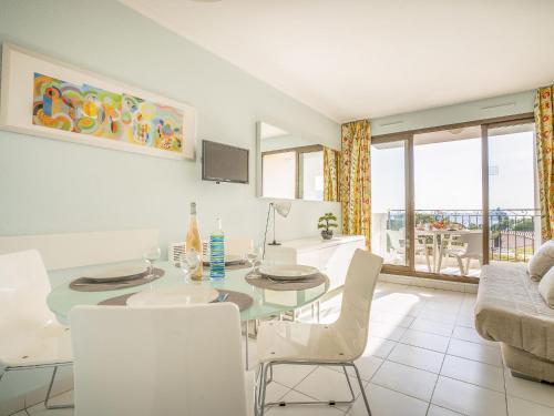 Apartment L'Ange Gardien by Interhome في بوليو سور مير: غرفة طعام وغرفة معيشة مع طاولة وكراسي