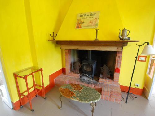 a living room with a fireplace and a yellow wall at Holiday Home Busani by Interhome in Castello di Contignaco