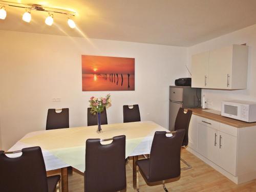 a dining room with a table with chairs and a microwave at Holiday Home Thaler by Interhome in Obernberg am Brenner