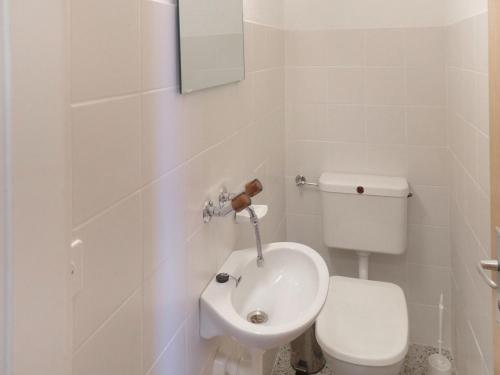 a white bathroom with a toilet and a sink at Apartment Armorial Est Apt- 72 by Interhome in Vermala