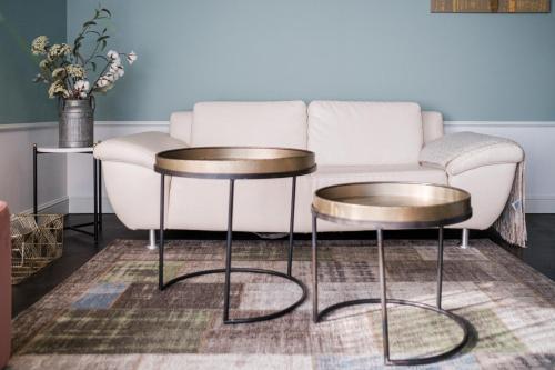 a living room with a couch and two tables at Mercure Hotel Pforzheim in Pforzheim