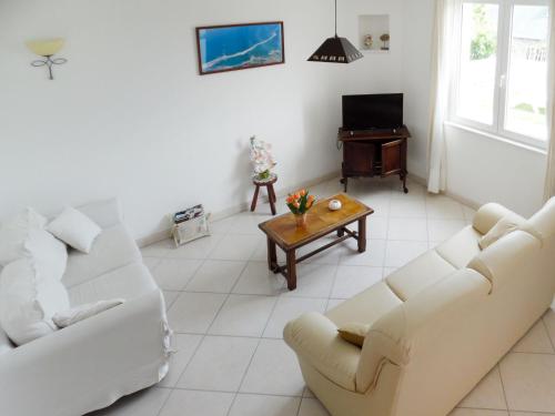 - un salon avec deux canapés blancs et une table dans l'établissement Holiday Home Le Sémaphore by Interhome, à Pleubian