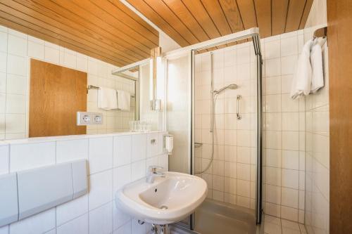 a white bathroom with a sink and a shower at Landgasthof Adler in Breisach am Rhein