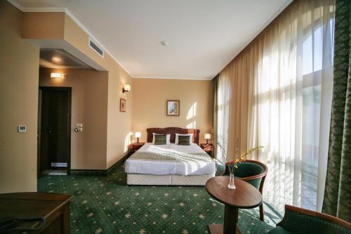 a hotel room with a bed and a large window at Retro Hotel in Haskovo