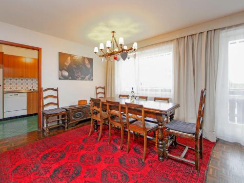 Apartment Center by Interhome في زيرمات: غرفة طعام مع طاولة وسجادة حمراء