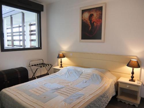 a bedroom with a bed and a painting on the wall at Apartment Le Golf Clair-1 by Interhome in Saint-Cyprien