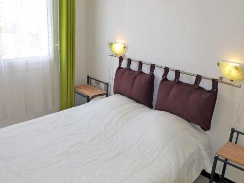 um quarto com uma grande cama branca e 2 candeeiros em Apartment Corsaires 63 by Interhome em Saint Pierre La Mer