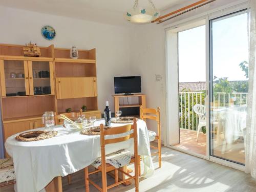 uma sala de jantar com uma mesa e uma varanda em Apartment Corsaires 63 by Interhome em Saint Pierre La Mer