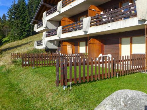 a house with a wooden fence in front of it at Apartment Licorne by Interhome in Les Rasses