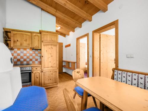 una cucina con mobili in legno, tavolo e sedie di Apartment Nadine-4 by Interhome a Sölden
