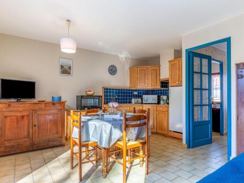 a kitchen with a table and chairs and a refrigerator at Holiday Home L'Orée des Bois by Interhome in Saint-Georges-de-Didonne