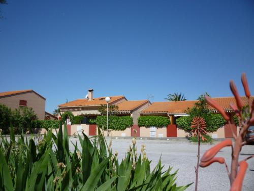 una fila de casas en un estacionamiento con plantas en Holiday Home Thalassa-3 by Interhome, en Saint Cyprien Plage
