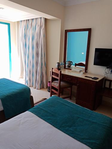 a hotel room with a desk and a mirror at Green Sudr Resort in Ras Sedr