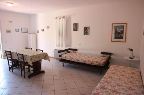 a room with two beds and a table and chairs at Azienda Agricola Sapereta in Porto Azzurro