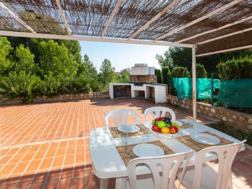 un patio con tavolo, sedie e griglia di Villa Llevant by Interhome a Calafat