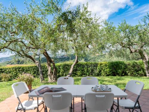 a table and chairs in a garden with trees at Apartment Alberto B by Interhome in Diano Castello