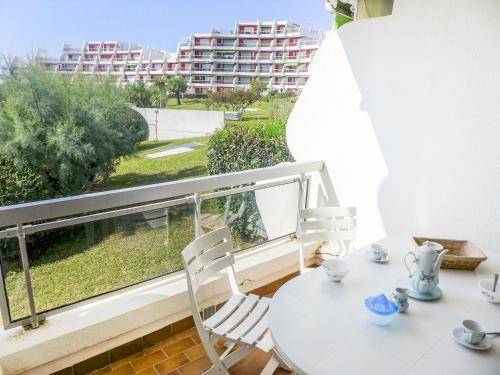 une table blanche et des chaises sur un balcon avec vue dans l'établissement Apartment Arena-4 by Interhome, à La Grande Motte