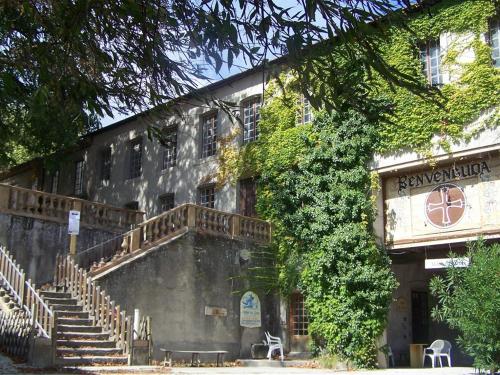 un viejo edificio con escaleras y hiedra. en APOSTROPHE Chambres d'Hôtes, en Montolieu