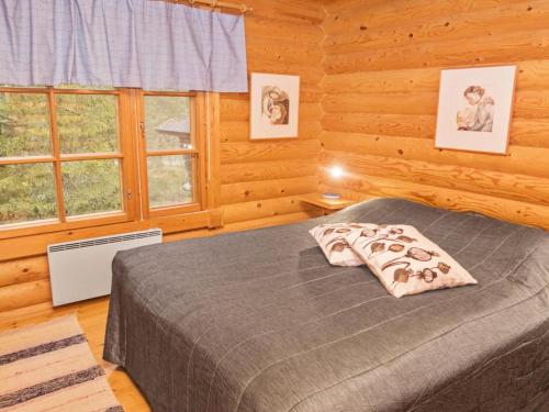 ein Schlafzimmer mit einem Bett in einer Blockhütte in der Unterkunft Holiday Home Varilan lomamajat nr2 by Interhome in Ruka