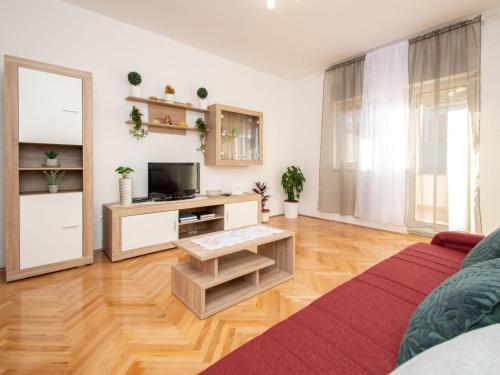 een woonkamer met een bank en een tv bij Apartment Šime by Interhome in Brodarica