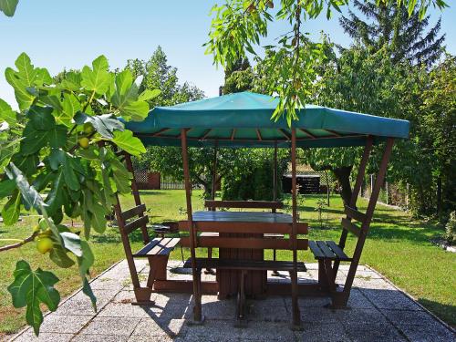 バラトンケレストゥールにあるHoliday Home Grand Jardin by Interhomeのピクニックテーブル(青い傘、ベンチ2台付)