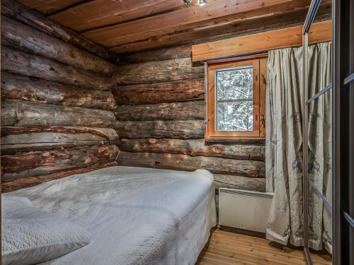 a bedroom with a bed in a log cabin at Holiday Home Seitsemän savua 6 by Interhome in Ruka