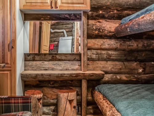 a log cabin bedroom with a bed and wooden walls at Holiday Home Seitsemän savua 6 by Interhome in Ruka