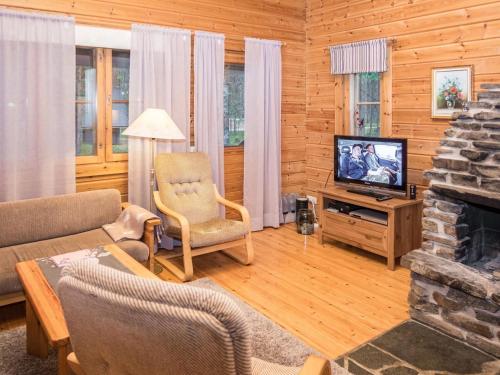 ein Wohnzimmer mit Kamin und Fernseher in der Unterkunft Holiday Home Purnukylä 6 by Interhome in Ruka