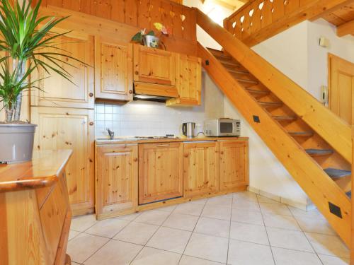 a kitchen with wooden cabinets and a staircase at Apartment Villa Placidia Apt 32 by Interhome in Campitello di Fassa