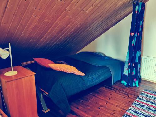 ein Bett in einem Zimmer mit Holzdecke in der Unterkunft Holiday Home Käenkukka in Luosto