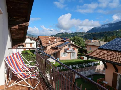 a balcony with a chair and a view of a town at Apartment Brida by Interhome in Caldonazzo