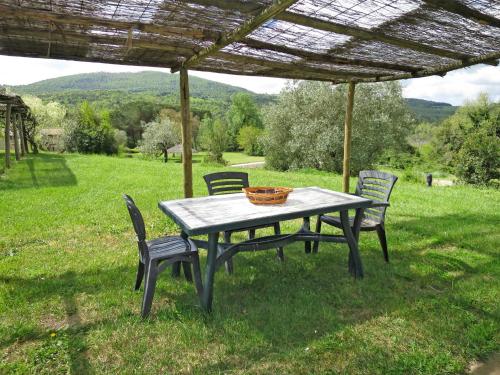 einem Picknicktisch mit vier Stühlen unter einer Pergola in der Unterkunft Holiday Home Ginestra by Interhome in Canneto