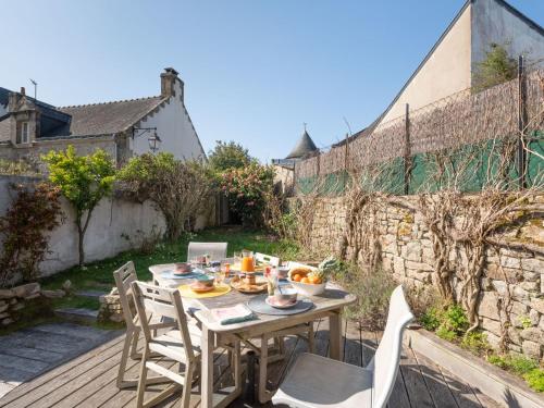 a wooden table and chairs on a wooden deck at Holiday Home la Voile by Interhome in La Trinité-sur-Mer