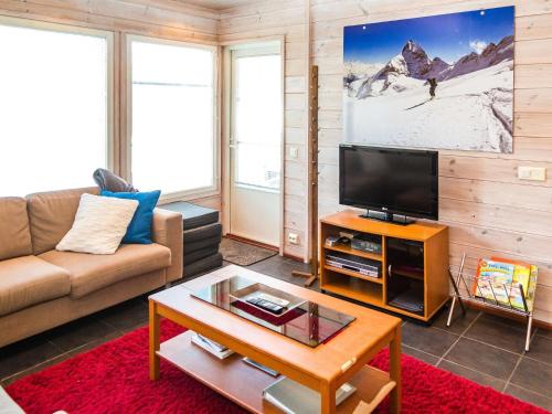 ein Wohnzimmer mit Sofa und Fernseher in der Unterkunft Holiday Home Alppituulahdus 10a by Interhome in Valkeinen