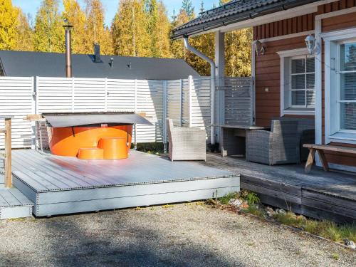 a deck with a fire pit on a house at Holiday Home Alppituulahdus 10a by Interhome in Valkeinen