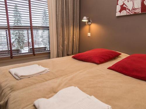 ターコブオリにあるHoliday Home Tahko spa junior suite orange a6 by Interhomeのベッドルーム1室(大型ベッド1台、赤い枕2つ付)