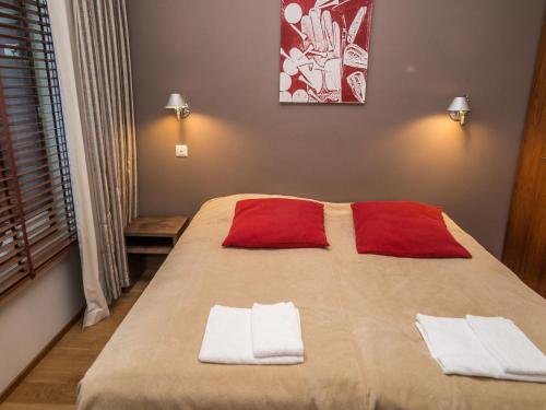 ターコブオリにあるHoliday Home Tahko spa junior suite orange a6 by Interhomeのベッドルーム1室(大型ベッド1台、赤と白のタオル付)