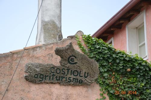 um sinal na lateral de um edifício em Agriturismo Costiolu em Nuoro