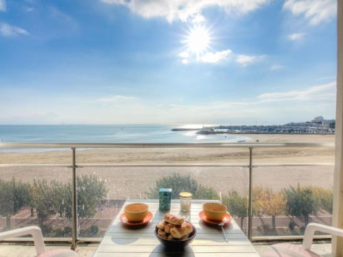 uma mesa com vista para a praia a partir de uma varanda em Apartment Les Autans by Interhome em Royan